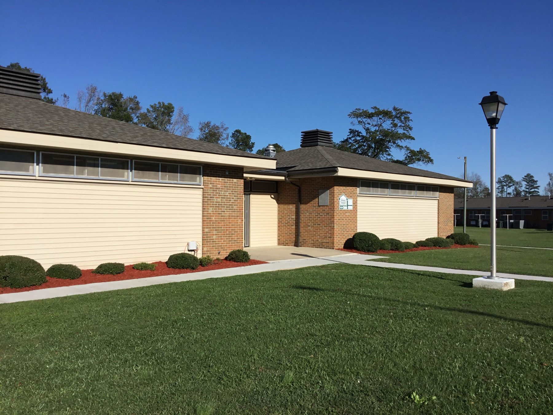 The Farmville Housing Authority administrative office, a single-storey brick building on a green lawn